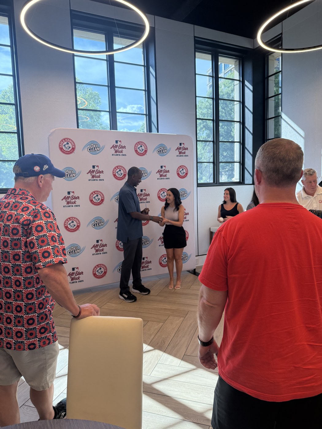 A baseball alumnus greeting a guest during an All-Star Week activation